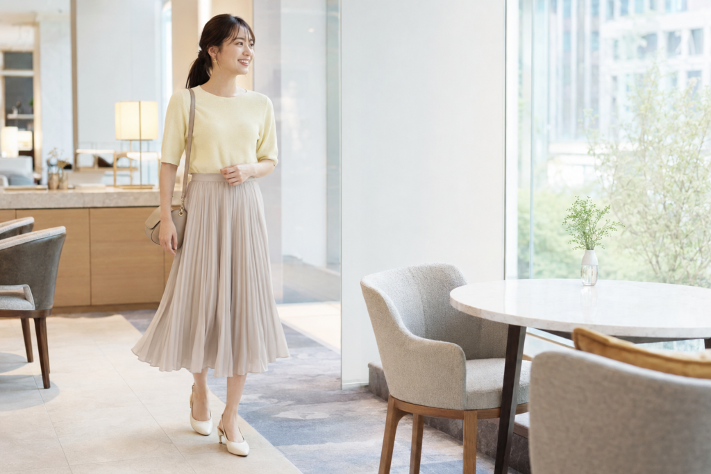 20代女性のお見合いに合う淡いイエローのニットとグレージュのプリーツスカートコーデ